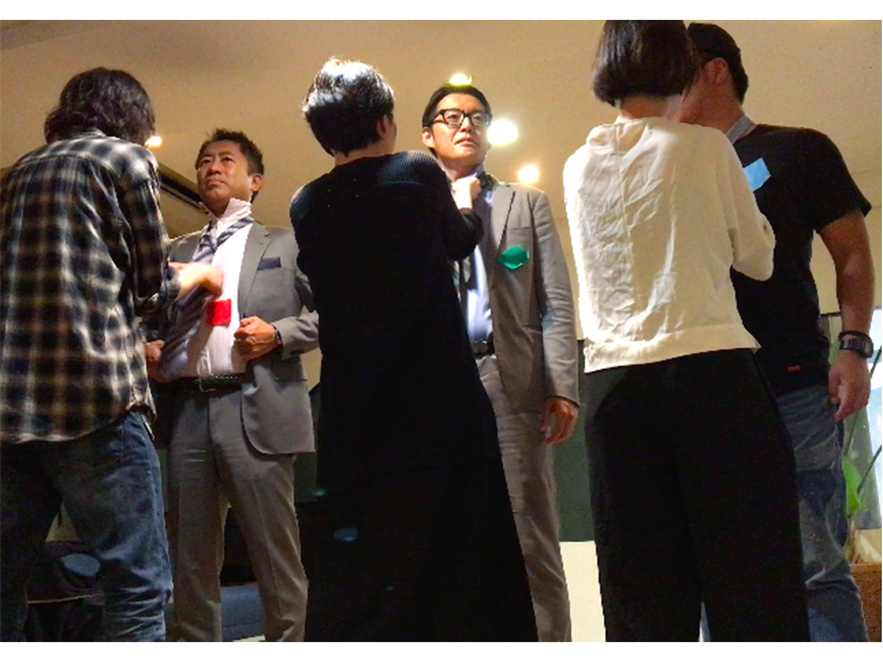▲「ネクタイ結んだことないから難しいな〜!」 と苦戦する女性メンバー。