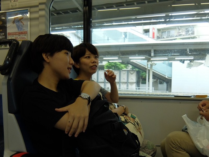 ▲電車の中、鎌倉で何をしようか話し合う広報メンバーたち。
